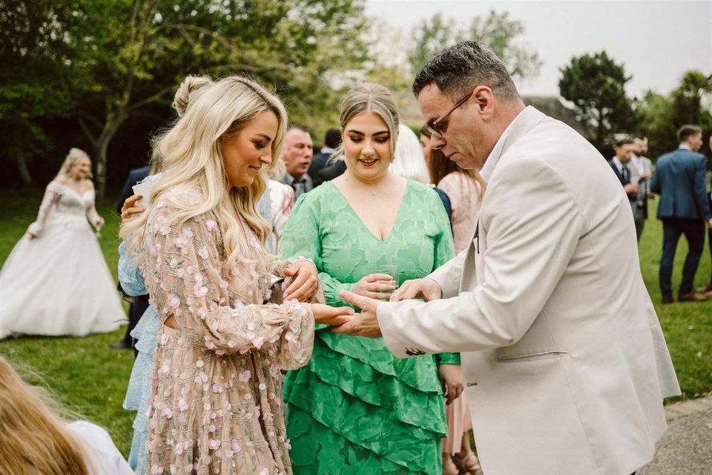 Close-up magician with guests at Leez Priory Tudor mansion wedding in Essex