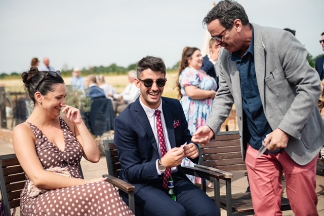 Award-winning close-up magician Andy Magicman performing interactive magic for guests at a private party celebration in the UK.