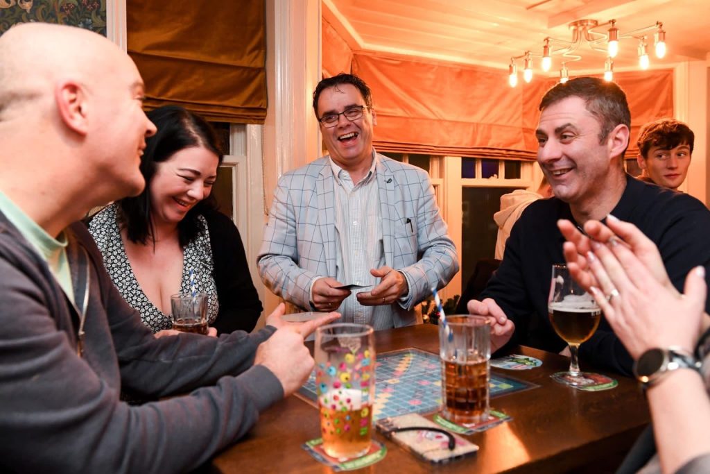 Award-winning restaurant magician Andy Magicman performing interactive close-up magic for diners during a restaurant entertainment evening in the UK.